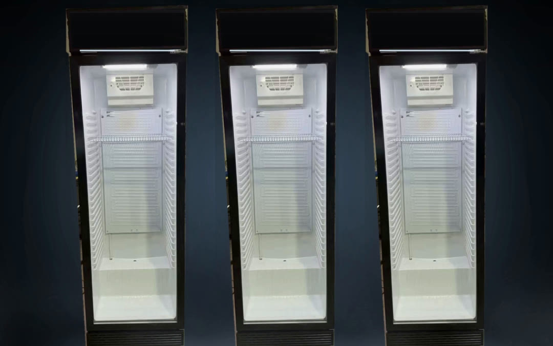 Three commercial glass-door refrigerators lit from inside against a dark wall